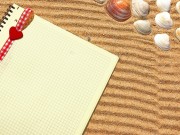 Yellow Checkered Notepad with bookmark in sand. Background with space for text or image